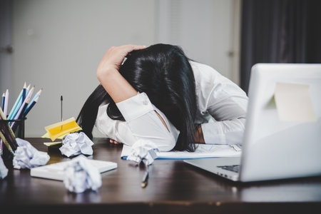 Stress business woman person from hard work, depression in office. Tired and anxious employee female with unhappy at problem job. young businesswoman sitting sad front of laptop computer on desk.の写真素材