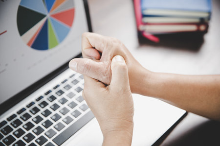 Arthritis person, finger woman ache from working in office. Concept office syndrome hand pain from occupational disease, woman having wrist pain from using laptop computer, wrist pain.の写真素材