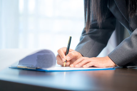 Workplace closeup person professional businesswoman sitting at desk hold pen signing or signature...