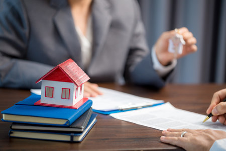 Woman home sales person is checking documents for house purchase contract before letting the customer sign contract on table is key with house model, real estate trading and insurance property conceptの写真素材