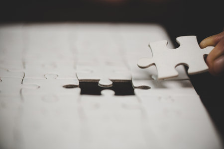 Business woman person hand with puzzle piece idea for strategy and solution. Closeup part of two white jigsaw connect together. Concept of join cooperation success teamwork-problem corporate team.の写真素材