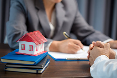 Woman home sales person is checking documents for house purchase contract before letting the customer sign contract on table is key with house model, real estate trading and insurance property conceptの写真素材