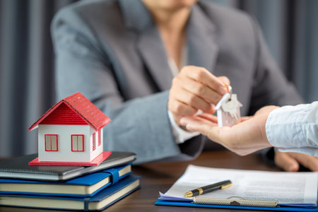 Woman home sales person is checking documents for house purchase contract before letting the customer sign contract on table is key with house model, real estate trading and insurance property conceptの写真素材