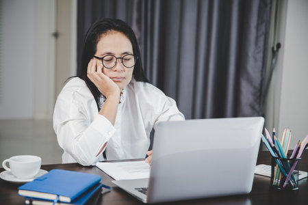 Stress business woman person from hard work, depression in office. Tired and anxious employee female with unhappy at problem job. young businesswoman sitting sad front of laptop computer on desk.の写真素材