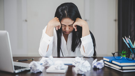 Stress business woman person from hard work, depression in office. Tired and anxious employee female with unhappy at problem job. young businesswoman sitting sad front of laptop computer on desk.の写真素材