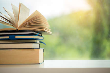 Object education green nature background with stack of ancient books or old bible, open paper book on wooden table with copy space. concept of back to school, research studyの写真素材