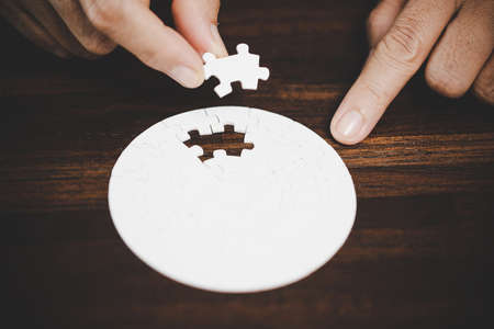Business woman person hand with puzzle piece idea for strategy and solution. Closeup part of two white jigsaw connect together. Concept of join cooperation success teamwork-problem corporate team.の写真素材