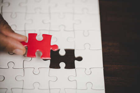 Business woman person hand with puzzle piece idea for strategy and solution. Closeup part of two white jigsaw connect together. Concept of join cooperation success teamwork-problem corporate team.の写真素材