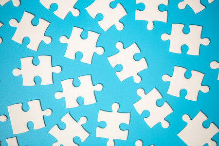 White part of jigsaw puzzle pieces on blue background. concepts of problem solving, business success, teamwork, Team playing jigsaw game incomplete, Texture photo with copy space for textの写真素材