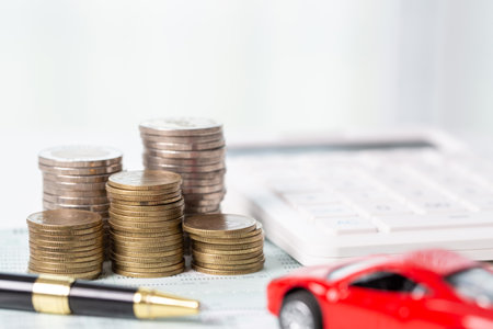 Car toy vehicle with stack coin money on background. Planning to manage transportation finance costs. Concept of car insurance business, saving buy - sale with tax and loan for new car.の写真素材