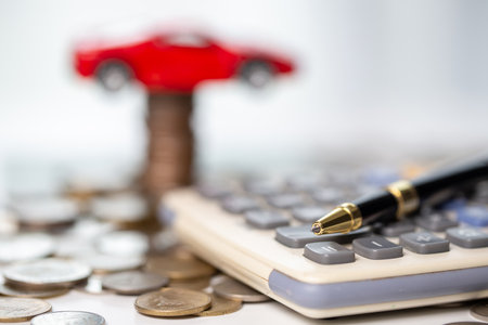 Car toy vehicle with stack coin money on background. Planning to manage transportation finance costs. Concept of car insurance business, saving buy - sale with tax and loan for new car.の写真素材