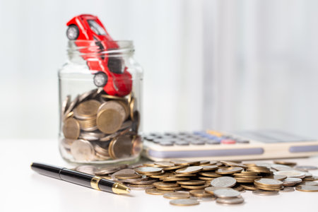 Car toy vehicle with stack coin money on background. Planning to manage transportation finance costs. Concept of car insurance business, saving buy - sale with tax and loan for new car.の写真素材