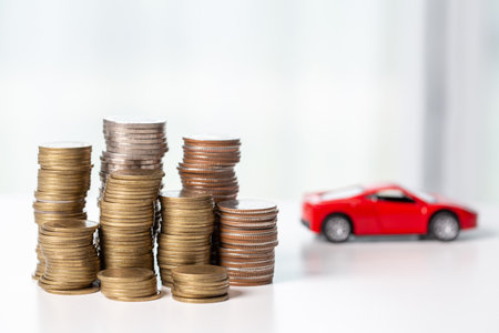 Car toy vehicle with stack coin money on background. Planning to manage transportation finance costs. Concept of car insurance business, saving buy - sale with tax and loan for new car.の写真素材