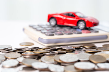 Car toy vehicle with stack coin money on background. Planning to manage transportation finance costs. Concept of car insurance business, saving buy - sale with tax and loan for new car.の写真素材