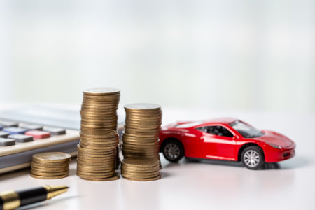 Car toy vehicle with stack coin money on background. Planning to manage transportation finance costs. Concept of car insurance business, saving buy - sale with tax and loan for new car.の写真素材