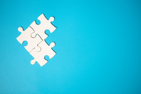 White part of jigsaw puzzle pieces on blue background. concepts of problem solving, business success, teamwork, Team playing jigsaw game incomplete, Texture photo with copy space for textの写真素材