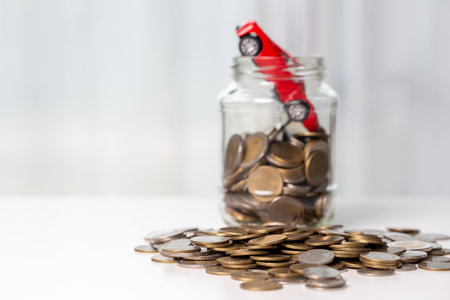 Car toy vehicle with stack coin money on background. Planning to manage transportation finance costs. Concept of car insurance business, saving buy - sale with tax and loan for new car.の写真素材