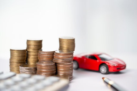 Car toy vehicle with stack coin money on background. Planning to manage transportation finance costs. Concept of car insurance business, saving buy - sale with tax and loan for new car.の写真素材