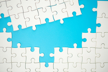 White part of jigsaw puzzle pieces on blue background. concepts of problem solving, business success, teamwork, Team playing jigsaw game incomplete, Texture photo with copy space for textの写真素材