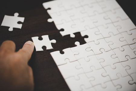 Business woman person hand with puzzle piece idea for strategy and solution. Closeup part of two white jigsaw connect together. Concept of join cooperation success teamwork-problem corporate team.の写真素材