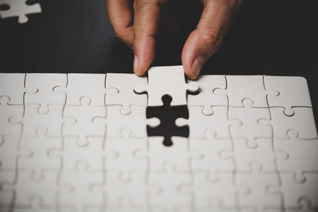 Business woman person hand with puzzle piece idea for strategy and solution. Closeup part of two white jigsaw connect together. Concept of join cooperation success teamwork-problem corporate team.の写真素材