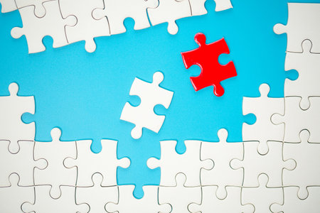 White part of jigsaw puzzle pieces on blue background. concepts of problem solving, business success, teamwork, Team playing jigsaw game incomplete, Texture photo with copy space for textの写真素材