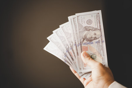 Banknote of 100 dollar bills in hands of rich woman person. Success business female holding cash money for investment. concept of saving finance, exchange bank, american currency, salary paymentの写真素材