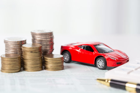 Car toy vehicle with stack coin money on background. Planning to manage transportation finance costs. Concept of car insurance business, saving buy - sale with tax and loan for new car.の写真素材