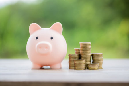 Savings for business investments concept. Money coin stacking on wood desk in green background. management cash, insurance asset and wealth, tax accounting budget, growth loan financial, economic.の写真素材