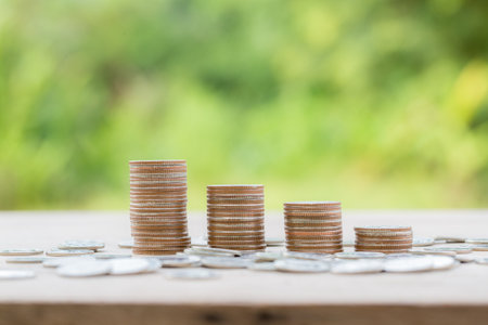 Money coin stacking on wood desk in green background. management cash, insurance asset and wealth, tax accounting budget, growth loan financial, economic, savings for business investments concept.の写真素材