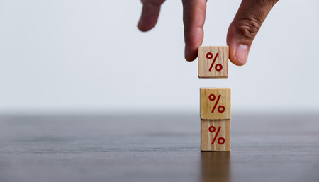 Closeup wood cubes with percentage symbol, Interest rate and dividend concept, wooden block with percentage symbol and up arrow, return on stocks and mutual funds, long term investment for retirement.の写真素材