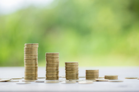 Money coin stacking on wood desk in green background. management cash, insurance asset and wealth, tax accounting budget, growth loan financial, economic, savings for business investments concept.の写真素材