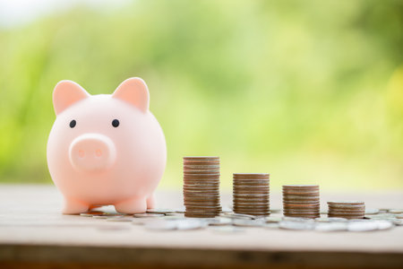 Savings for business investments concept. Money coin stacking on wood desk in green background. management cash, insurance asset and wealth, tax accounting budget, growth loan financial, economic.の写真素材