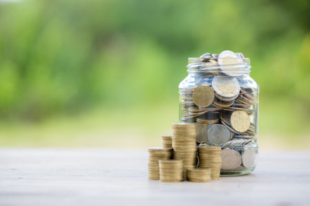 Savings for business investments concept. Money coin stacking on wood desk in green background. management cash, insurance asset and wealth, tax accounting budget, growth loan financial, economic.の写真素材