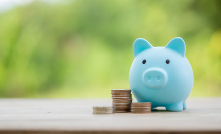 Savings for business investments concept. Money coin stacking on wood desk in green background. management cash, insurance asset and wealth, tax accounting budget, growth loan financial, economic.の写真素材