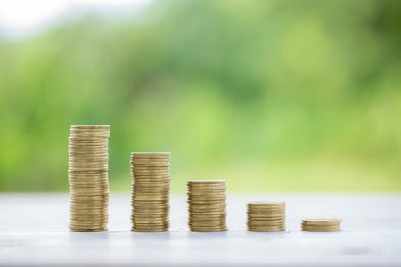 Money coin stacking on wood desk in green background. management cash, insurance asset and wealth, tax accounting budget, growth loan financial, economic, savings for business investments concept.の写真素材