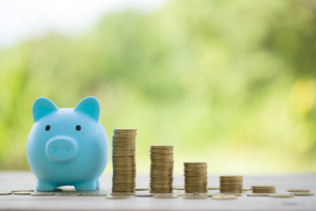 Savings for business investments concept. Money coin stacking on wood desk in green background. management cash, insurance asset and wealth, tax accounting budget, growth loan financial, economic.の写真素材