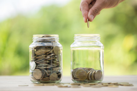 Female hand holding or putting money coin for saving. management cash, insurance asset and wealth, tax accounting budget, growth loan financial, economic, savings for business investments concept.の写真素材