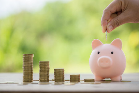 Female hand holding or putting money coin for saving. management cash, insurance asset and wealth, tax accounting budget, growth loan financial, economic, savings for business investments concept.の写真素材
