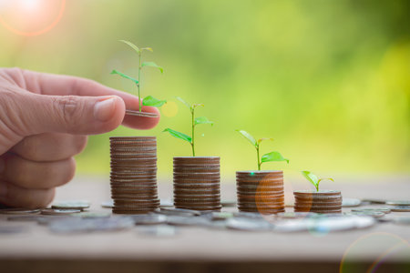 Hand putting money coin. Money coin stack growing graph with piggy bank saving concept. business finance and saving money investment, plant growing up on coin. Balance savings and investment.の写真素材