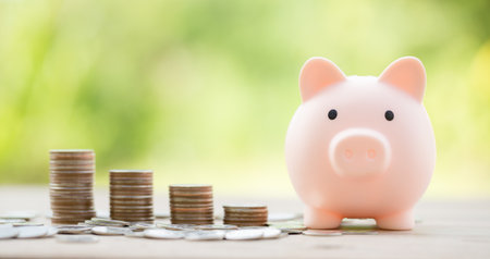 Savings for business investments concept. Money coin stacking on wood desk in green background. management cash, insurance asset and wealth, tax accounting budget, growth loan financial, economic.の写真素材