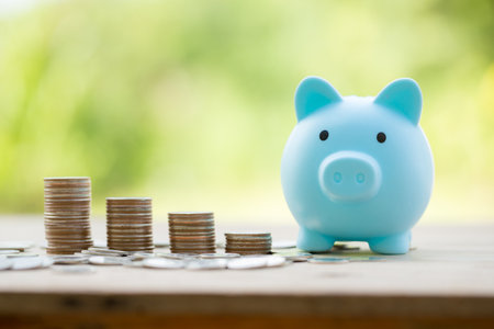 Savings for business investments concept. Money coin stacking on wood desk in green background. management cash, insurance asset and wealth, tax accounting budget, growth loan financial, economic.の写真素材