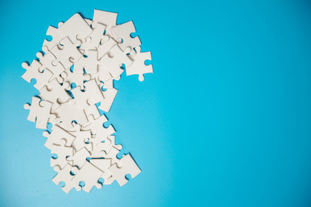 White part of jigsaw puzzle pieces on blue background. concepts of problem solving, business success, teamwork, Team playing jigsaw game incomplete, Texture photo with copy space for textの写真素材