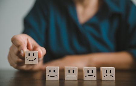 Satisfaction survey concept. Customer services best excellent business rating experience. Hand of business chooses a smile face on wood block circle. 5 Star Satisfaction. People feel great product.の写真素材