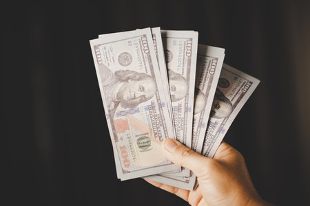 Banknote of 100 dollar bills in hands of rich woman person. Success business female holding cash money for investment. concept of saving finance, exchange bank, american currency, salary paymentの写真素材