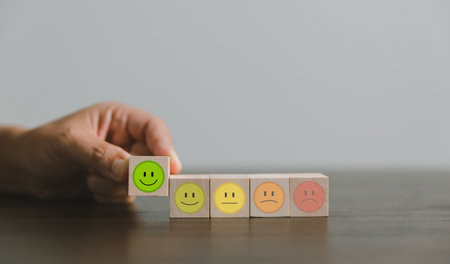 Satisfaction survey concept. Customer services best excellent business rating experience. Hand of business chooses a smile face on wood block circle. 5 Star Satisfaction. People feel great product.の写真素材