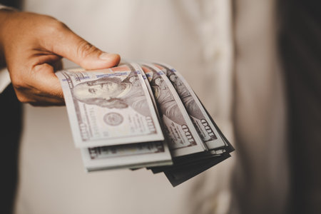 Banknote of 100 dollar bills in hands of rich woman person. Success business female holding cash money for investment. concept of saving finance, exchange bank, american currency, salary paymentの写真素材