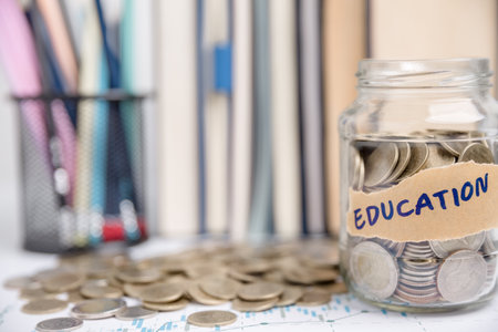 Concept to saving money income for study, Calculating student finance costs and investment budget loan. close-up education object with stack money coin-cash dollar and glass jar on background.の写真素材