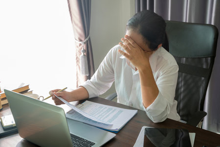 Stress business woman person from hard work, depression in office. Tired and anxious employee female with unhappy at problem job. young businesswoman sitting sad front of laptop computer on desk.の写真素材