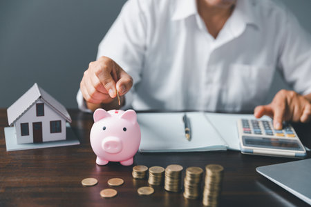 Saving investment home with loan finance money business concept. Investment banking finance for residential real estate business. Stack coins with model house for investment loans.Cash for taxes.の写真素材